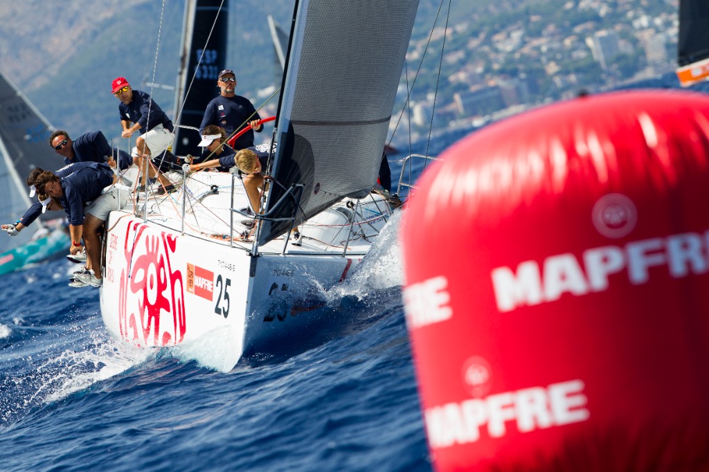 Velero de competición KUNDAKA en regata, tripulación en plena maniobra